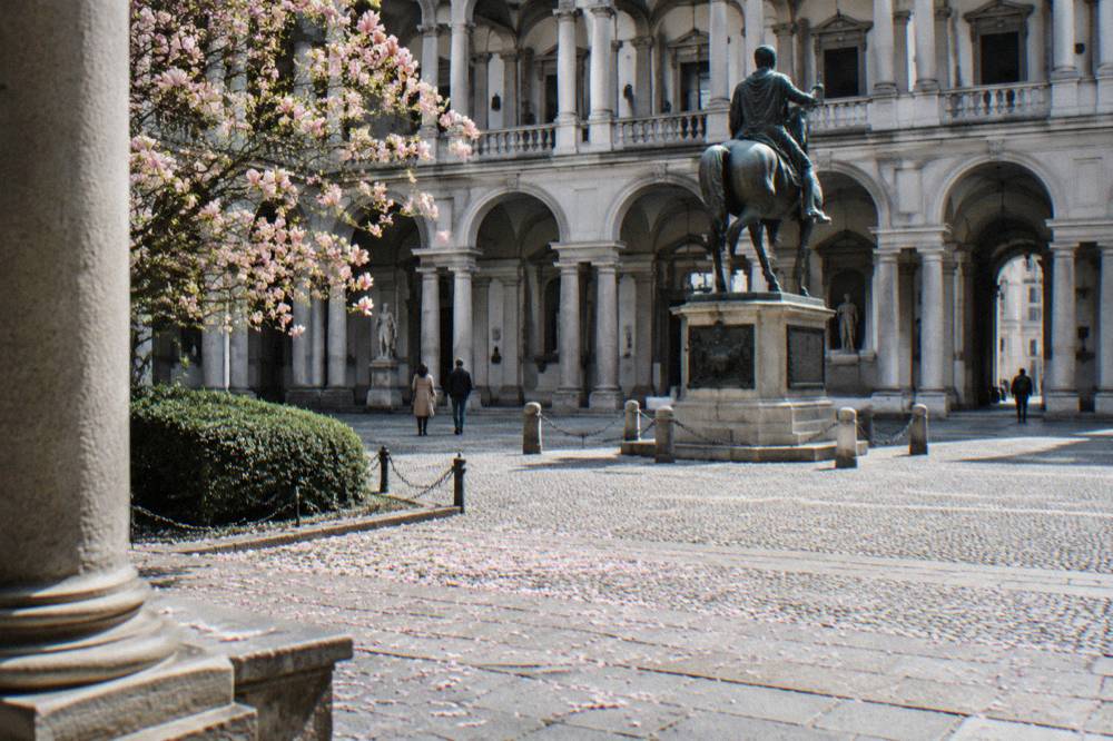 The grand neoclassical facade of the Pinacoteca di Brera with a statue of Napoleon in the courtyard