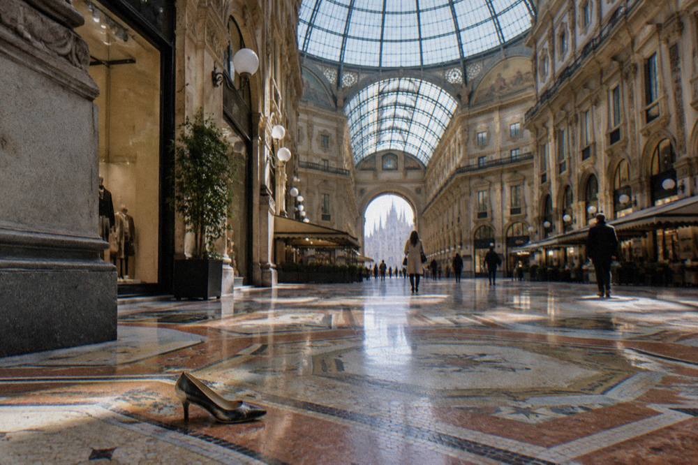 Interior of a glass-roofed shopping arcade with a central octagonal dome and patterned mosaic floor