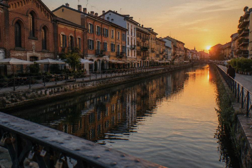 Warm evening light on canal-side facades and reflections in the Naviglio Grande water