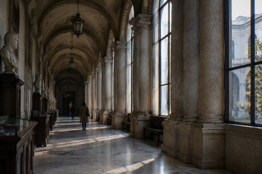 Long stone arcade in Milan with arched windows and soft morning light on the columns