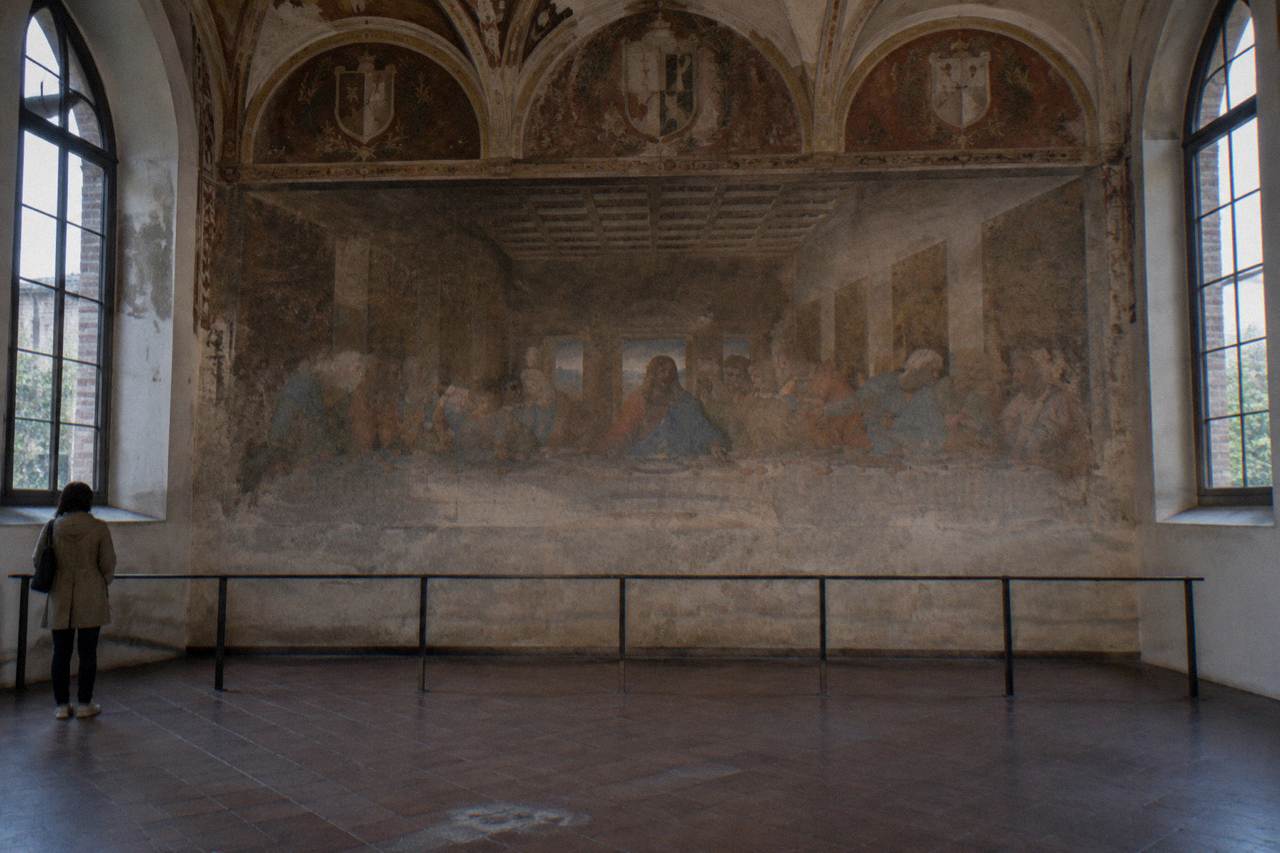 The refectory wall of Santa Maria delle Grazie in Milan showing Leonardo da Vinci's Last Supper fresco under soft gallery lighting