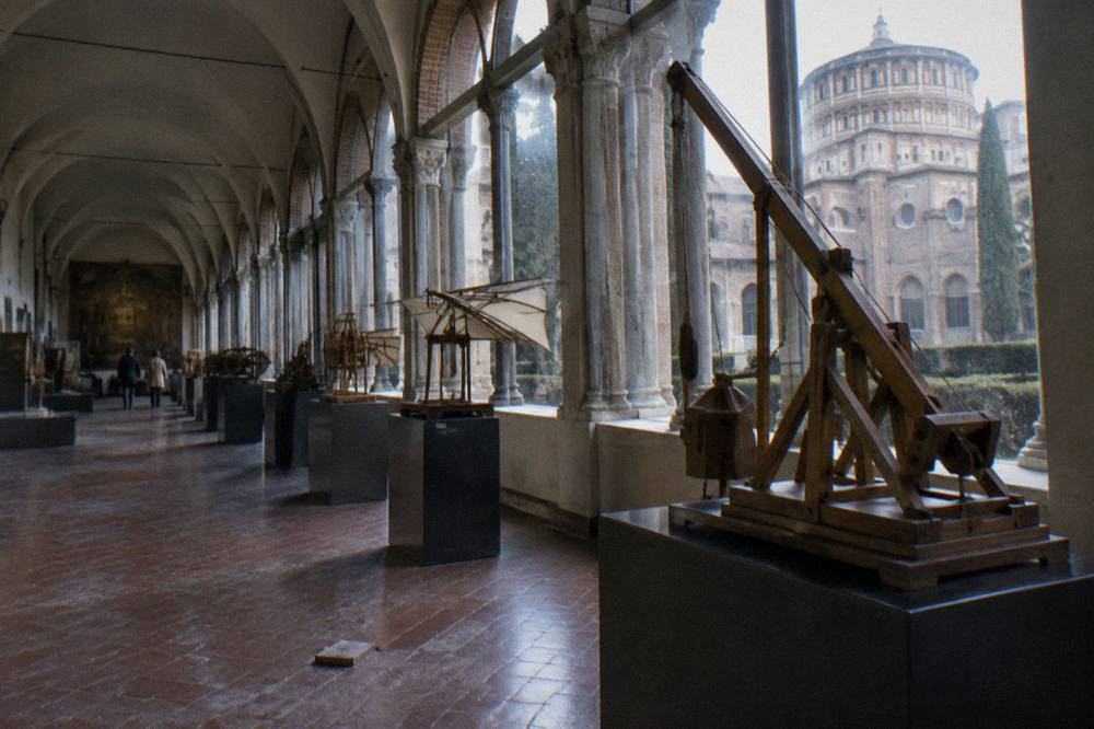 Interior hall of a science museum with historic machinery and wooden Leonardo model exhibits