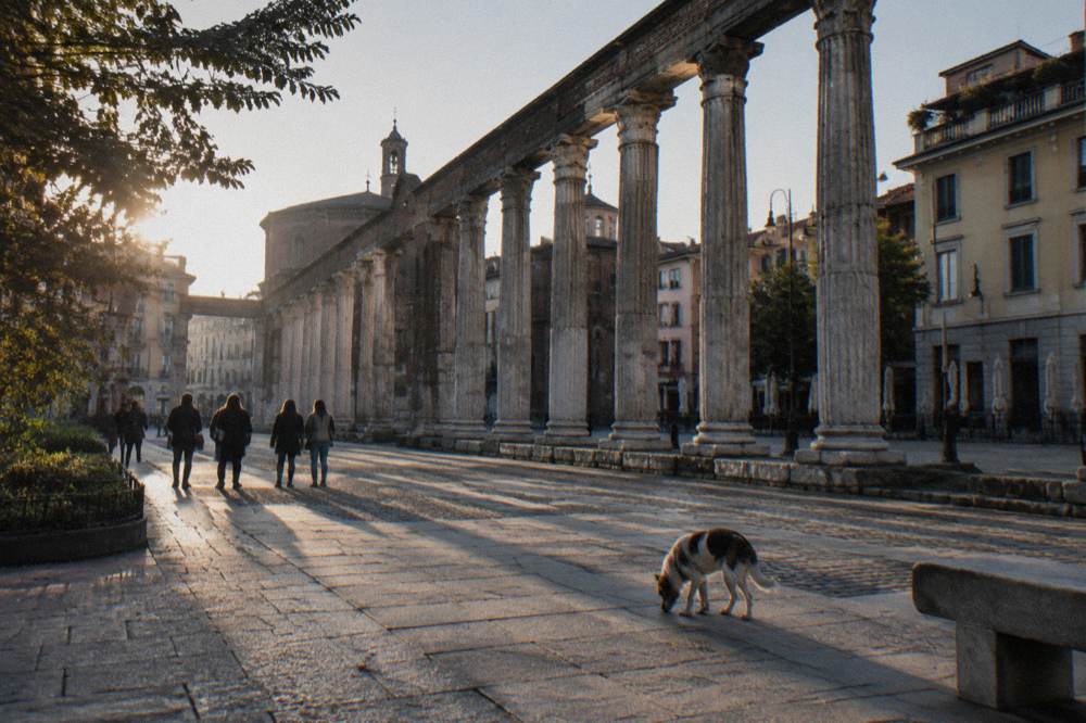 Guided walking group pausing in a Milan square near the cathedral