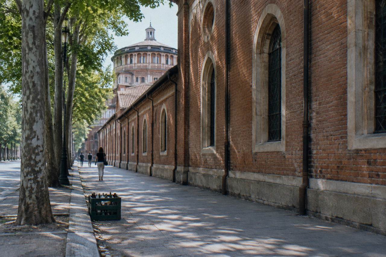 Historic monastery building housing a science and technology museum beside a Milan street