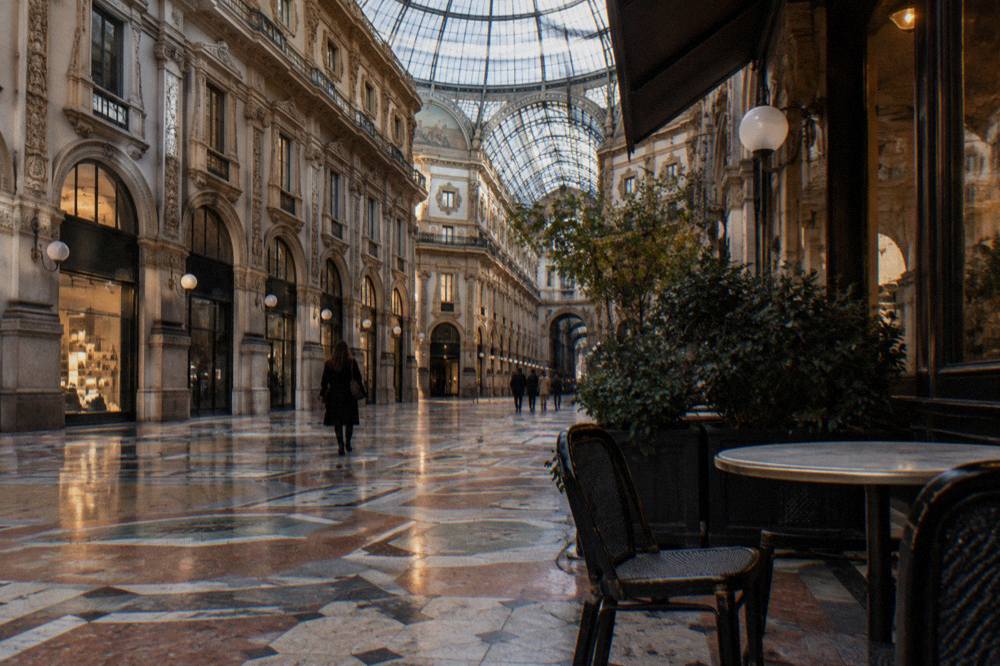 Elegant shopping arcade interior with glass vaulted ceiling and marble floors under ornate decoration