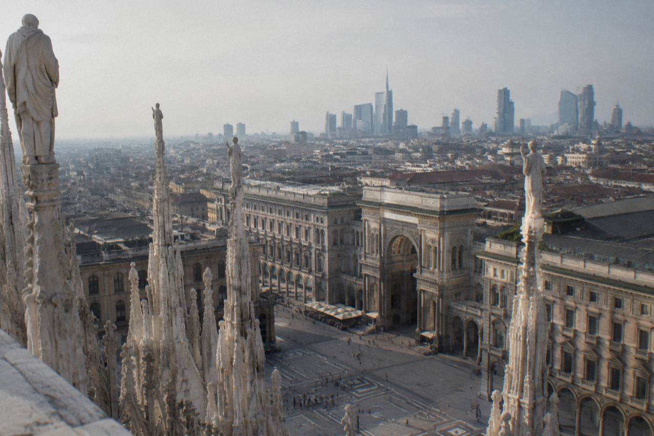Milan skyline with the Duomo spires and modern tower blocks rising behind rooftops