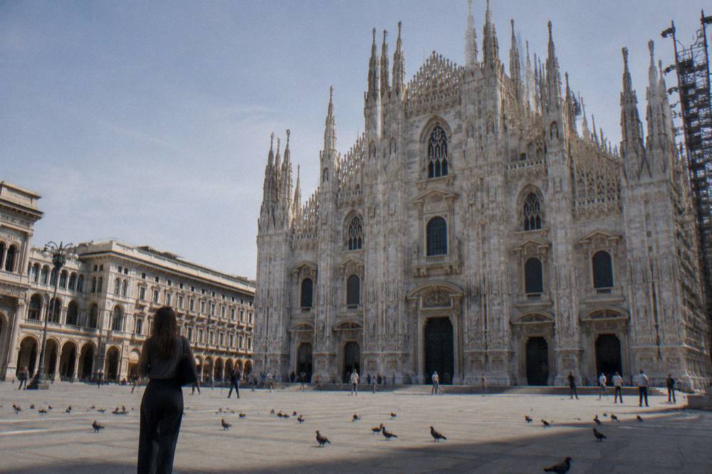 Gothic cathedral facade with spires and statues rising above a large open square