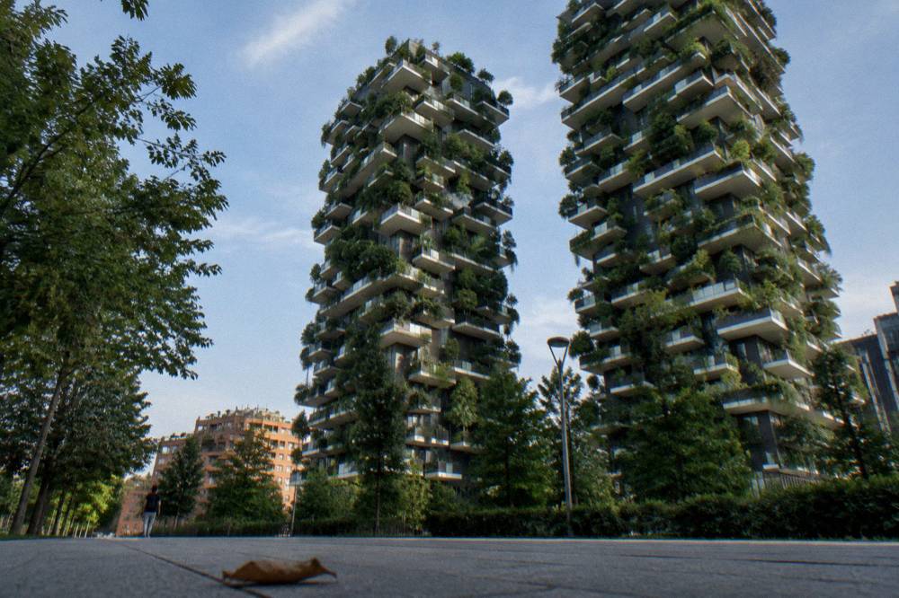 Tree covered residential towers of the Bosco Verticale seen from the street below
