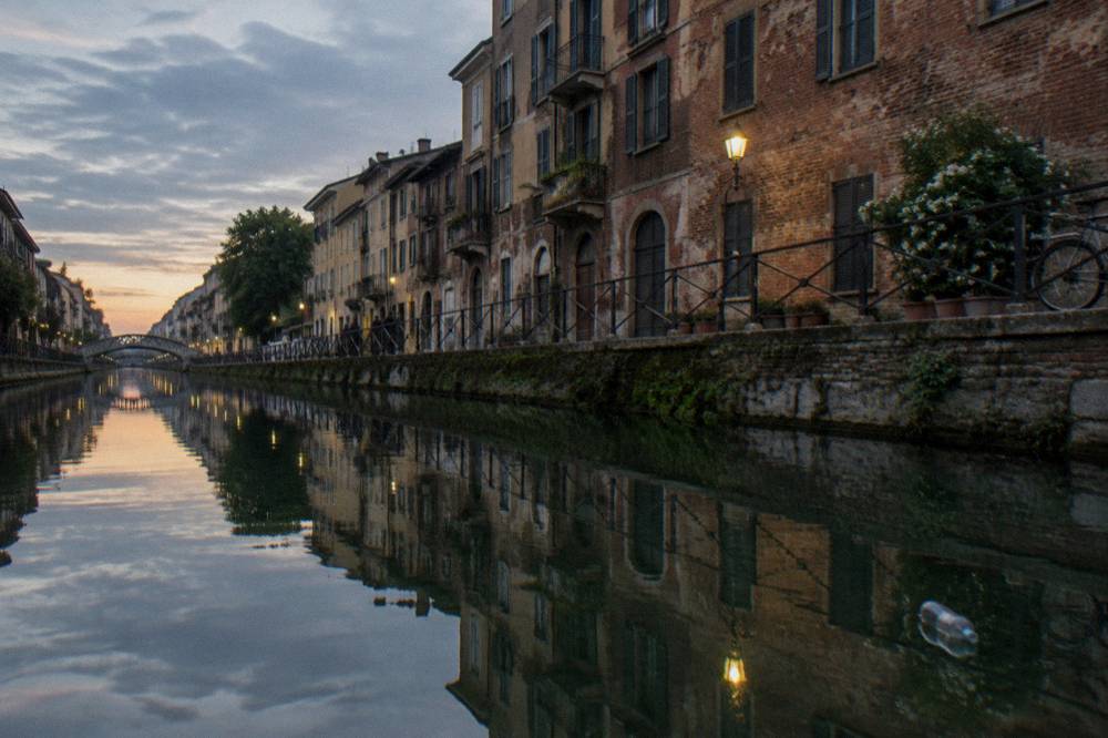 Canal-side buildings reflected in the Naviglio Grande water at dusk