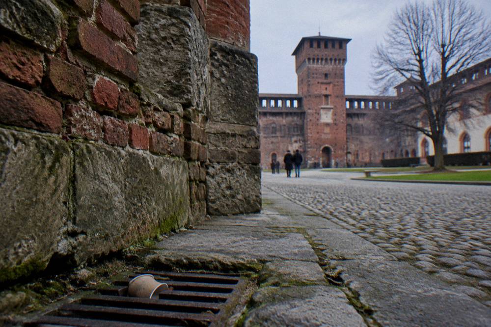 Stone castle courtyard with arcaded walls seen from a public path