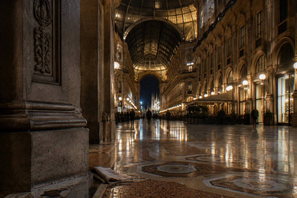 The Galleria Vittorio Emanuele II glass vault illuminated at night with its mosaic floor below