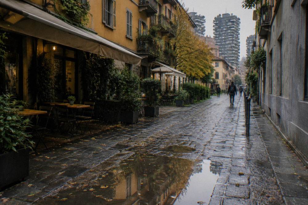 Cobblestone Milan street with cafe tables and historic building facades
