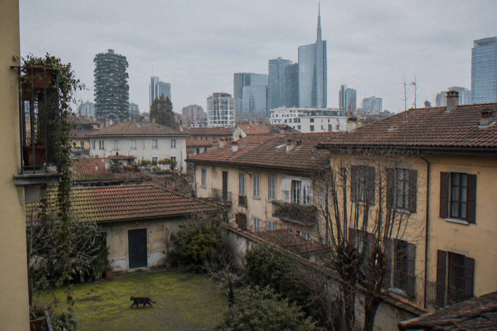 Older residential buildings in Isola with modern Porta Nuova towers visible above the rooftops