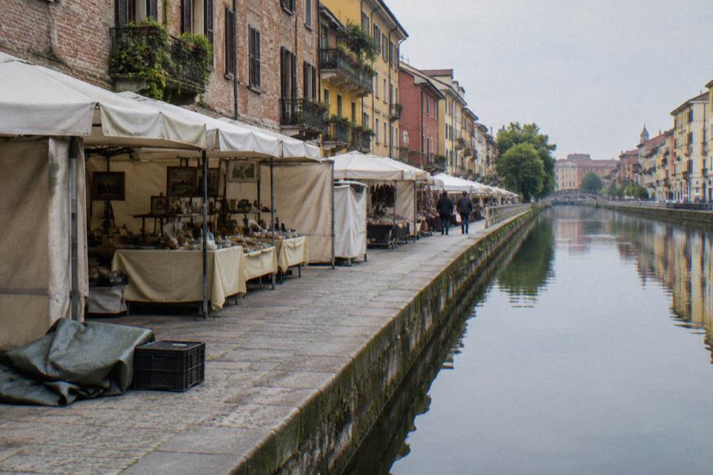 Canal-side market stalls set out along a Milan towpath