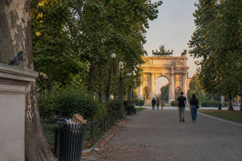 Tree-lined central path in Parco Sempione leading toward the Arco della Pace