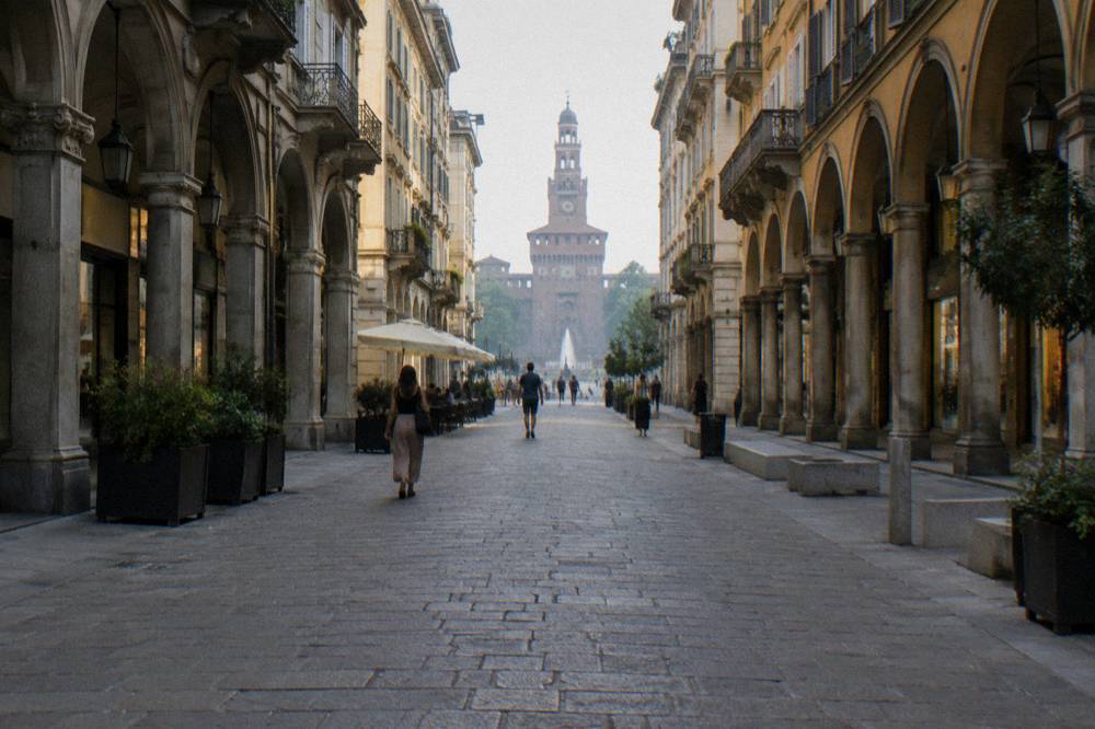 The pedestrian street Via Dante leading toward the Sforza Castle towers
