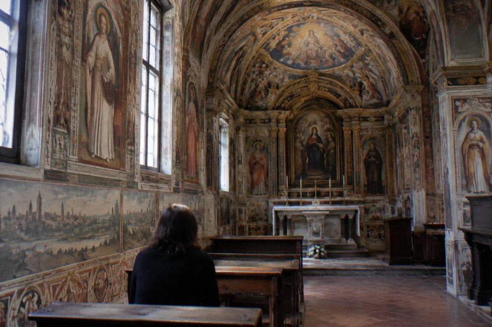 Frescoed church interior with painted scenes covering the walls and vault